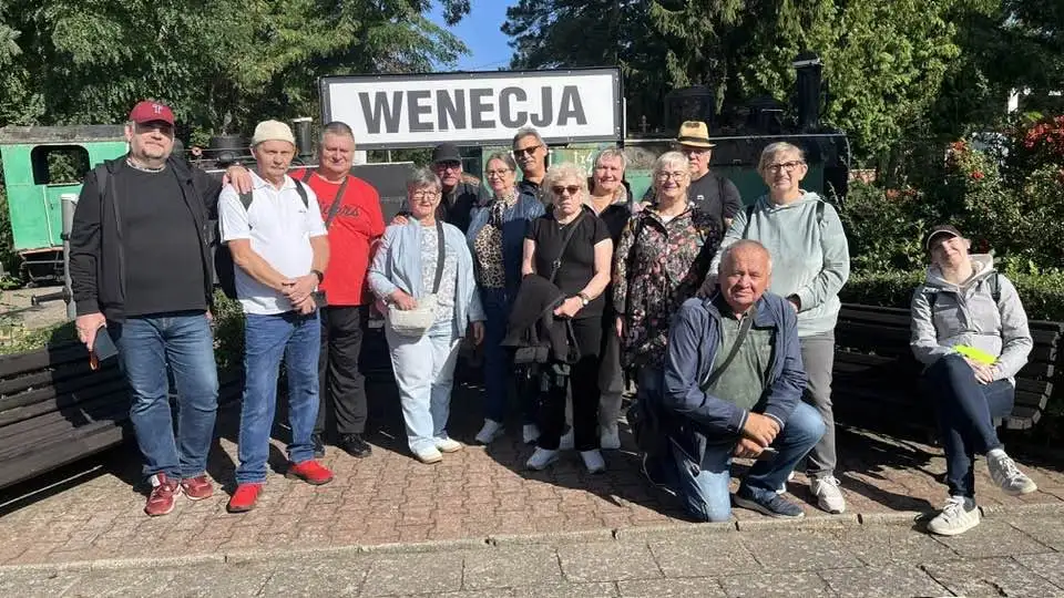 grupka osób pozująca do zdjęcia przy napisie Wenecja